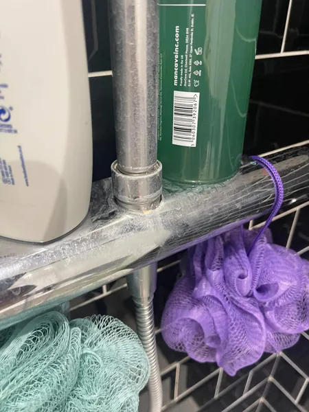 Close-up of a chrome shower mixer and rail beside shower products